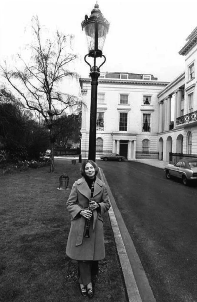 Amelia Freedman standing outdoors with a clarinet.